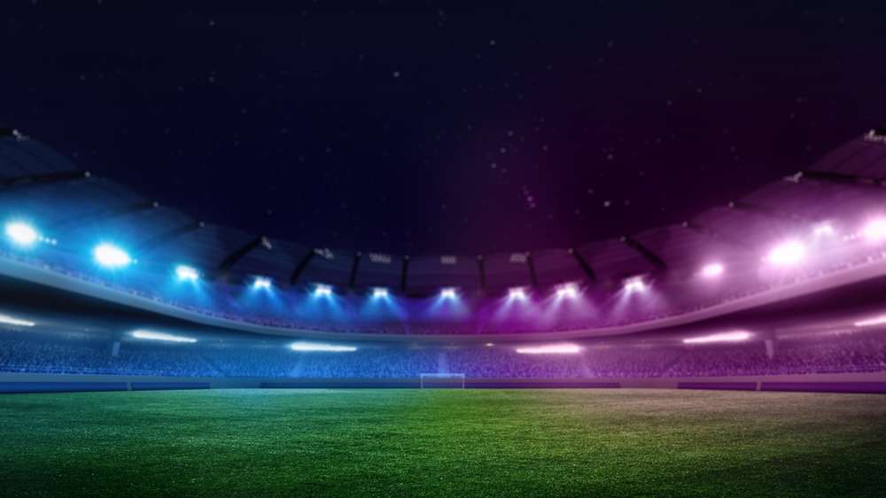 Soccer,Stadium,Field,With,Green,Grass,Illuminated,Blue,And,Purple